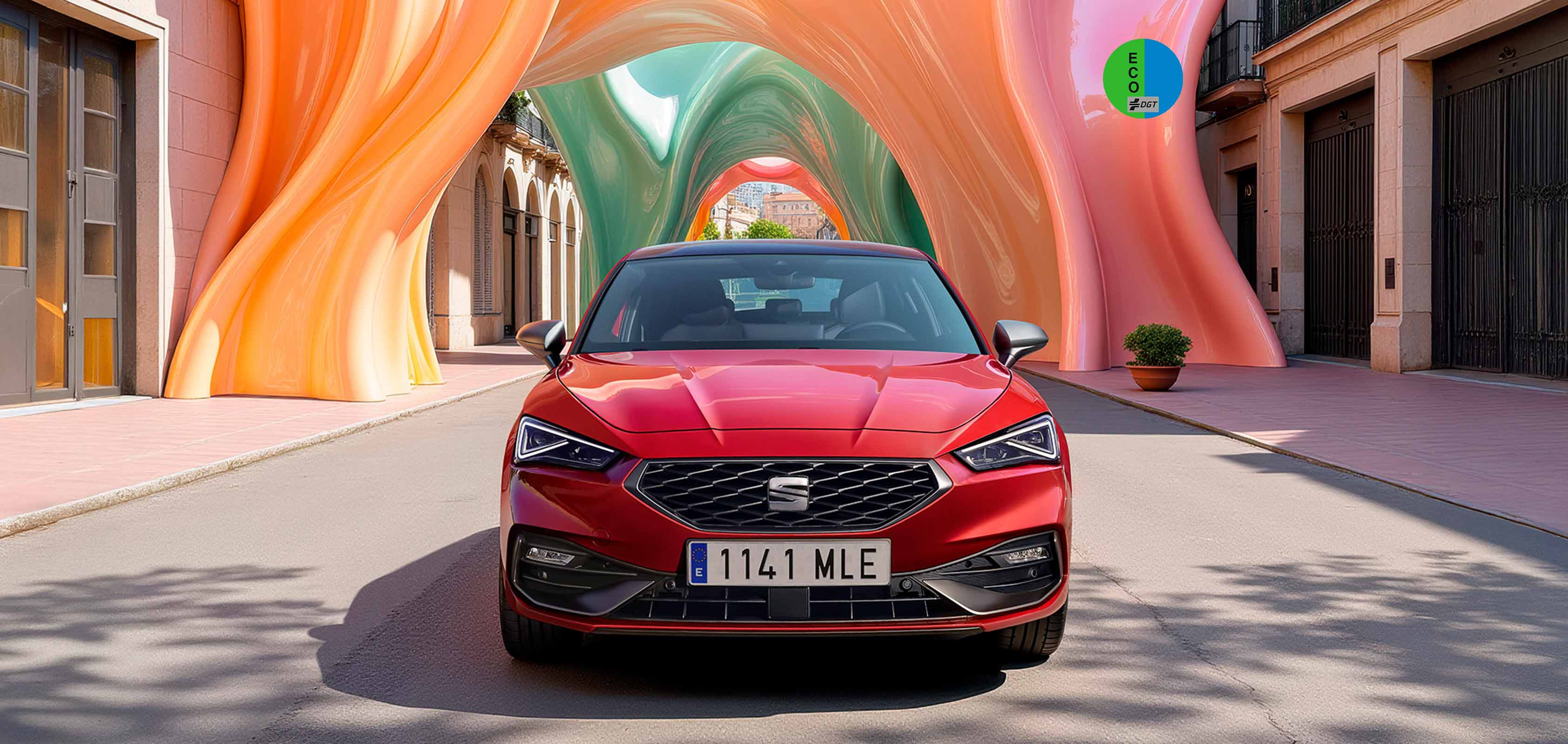 SEAT León Sportstourer familiar deportivo híbrido en color rojo desire de oferta en Canarias vista frontal entre edificios